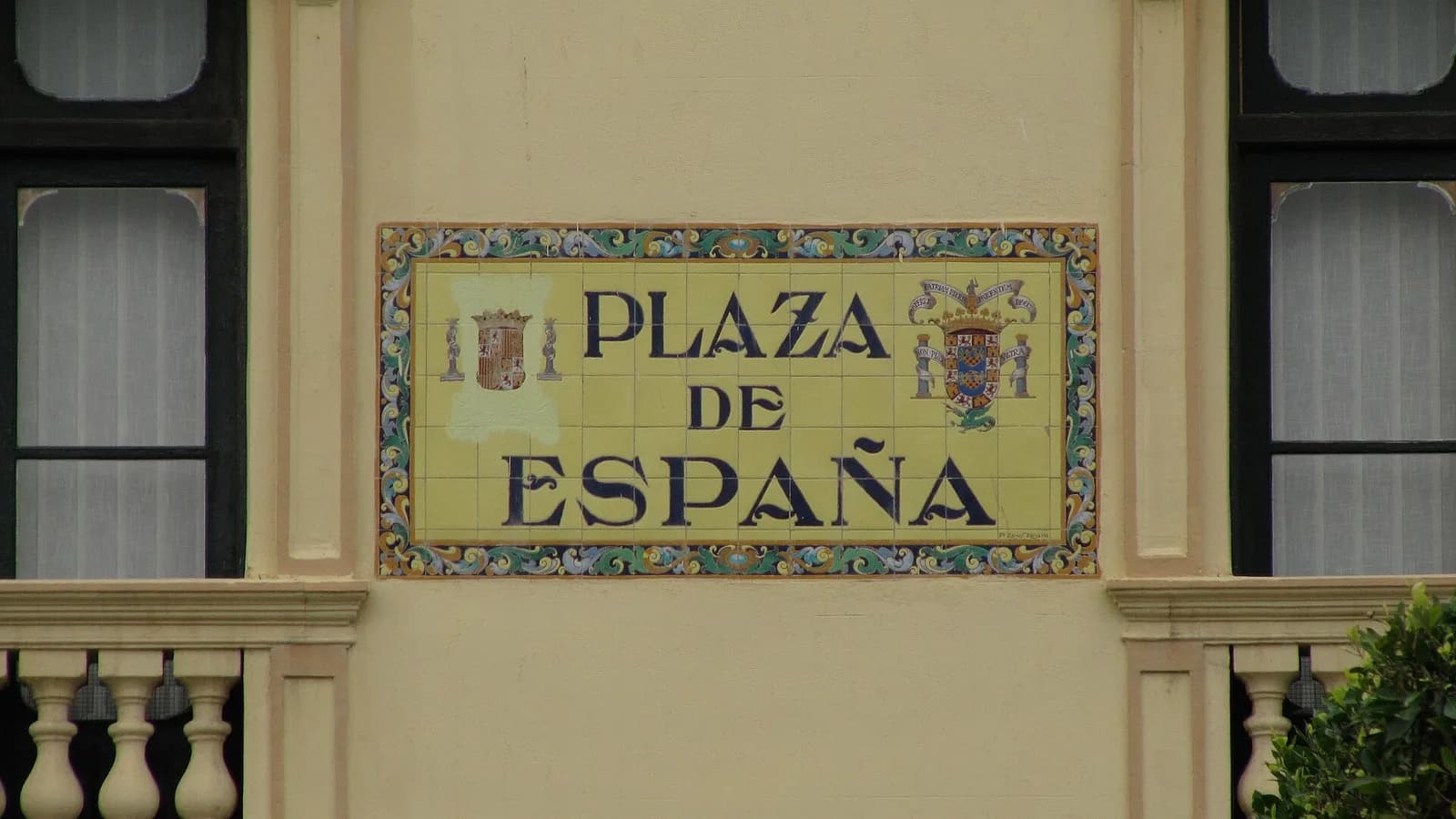 Azulejo que preside la fachada principal del Casino Militar y que nombra la Plaza de España de Melilla. Se observa como, con pintura amarilla y en aplicación de la Ley de Memoria Histórica, se ha eliminado el águila franquista del escudo de España